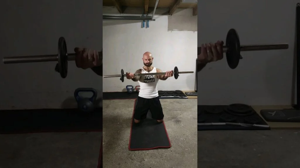 Élévation frontale à genou barre supination (kneeling underhand barbell front raise)