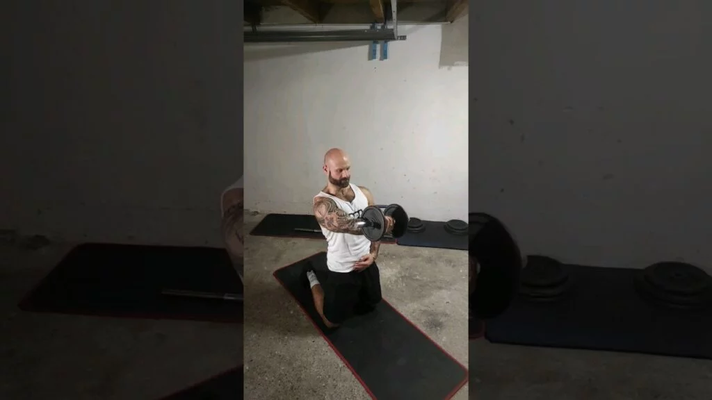 Élévation frontale à genou haltère supination à un bras (kneeling one arm underhand dumbbell front raise)
