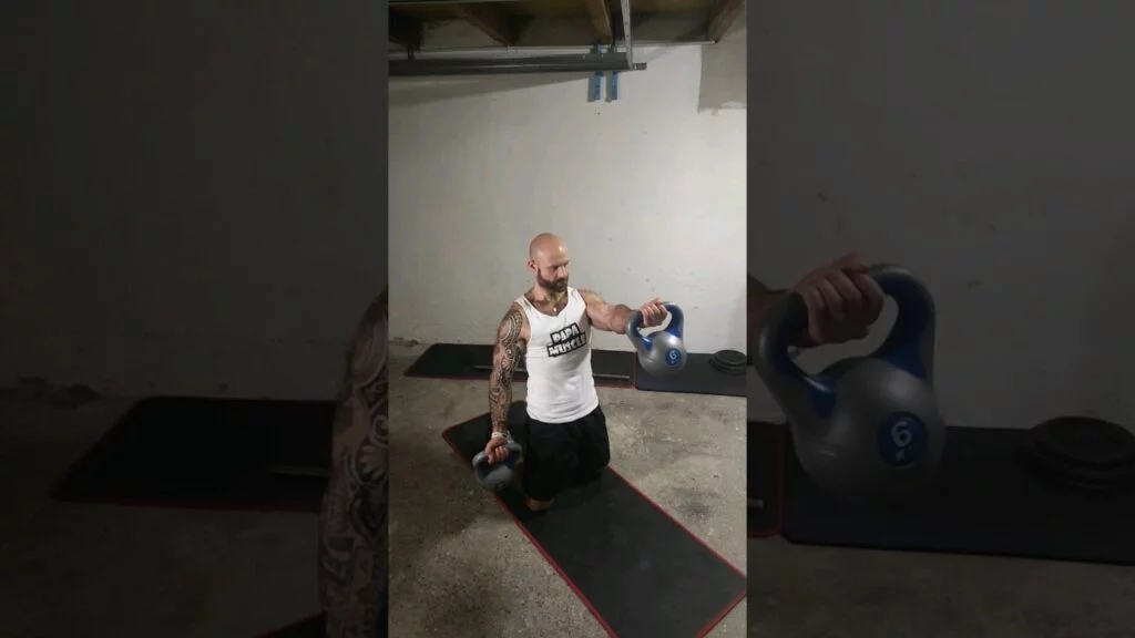 Élévation frontale à genou kettlebell supination alterné (alternating kneeling underhand kettlebell front raise)